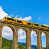 Sale Gele trein op een viaduct in Frankrijk fotobehang Transport | Architectuur