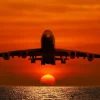 Best Passagiersvliegtuig boven de zee bij zonsondergang fotobehang Transport