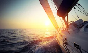 Online Zeilboot bij zonsondergang fotobehang Transport